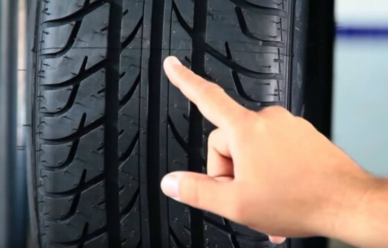 Mão apontando para pneu de carro