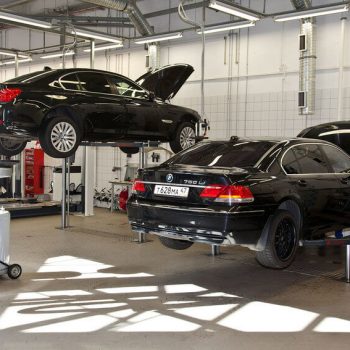 Dois carro BMW em processo de revisão em centro automotivo